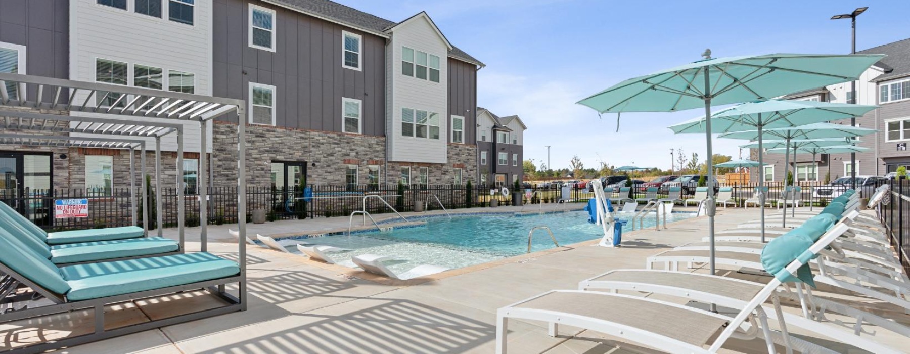 a swimming pool with lounge chairs and umbrellas by it