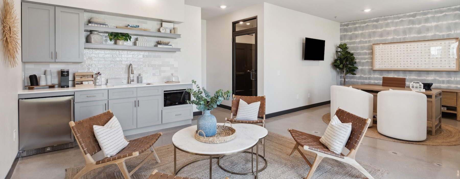 a clubroom with a kitchen and a lounge area with tables and chairs